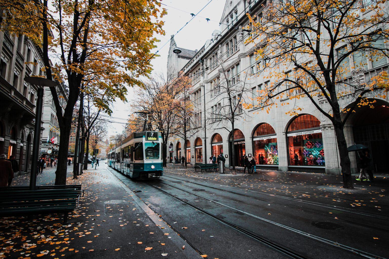 Een winkelstraat waar een tram in rijdt.